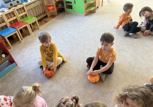 Chłopiec i dziewczynka z dyniami.