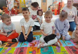 Dziewczynka trzyma świnkę morską na kolanach.