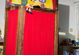 Smutna mama czerwonego kapturka siedzi na teatrzyku.