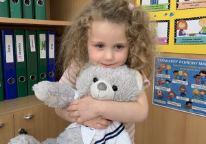 Dziewczynka przytula Misia Karola.