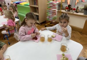 Dziewczynki zajadają owocowymi jeżami.