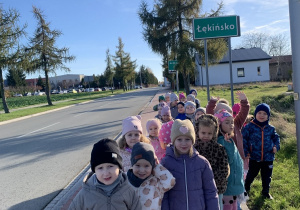 Dzieci przed tablicą miejscowości - Łękińsko.