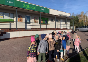 Przedszkolaki koło sklepu Żabka.