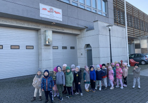 Zdjęcie na tle budynku Straży Pożarnej.