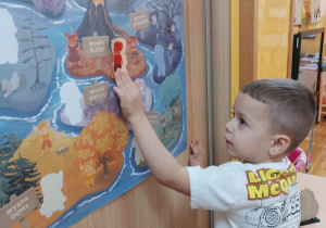 Chłopiec nakleja gniewka na plakacie