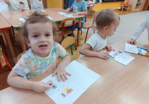 Chłopiec wkleja ilustrację Gniewka do książeczki