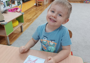 Chłopiec koloruje postać Gniewka