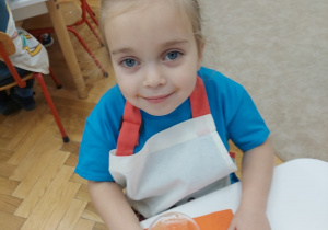 Dziewczynka smakuje sok zrobiony przez wszystkie dzieci.