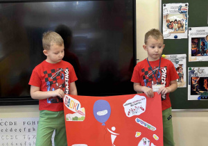 Chłopcy z grupy 5 latków trzymają plakat.