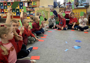 Dzieci pokazują zielone karteczki.