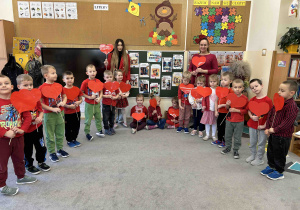 Dzieci z grupy 5 latków trzymają serca do wspólnego zdjęcia.