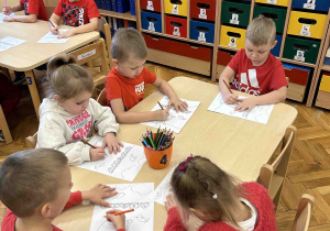 Dzieci kolorują przy stoliczkach.