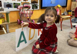 Dziewczynka zawiesza literę A.