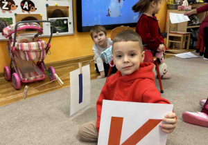 Chłopiec trzyma literę K.