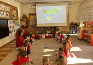 Dzieci oglądają animację na dużym ekranie.