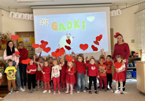 Dzieci z grupy 4 latków trzymają serduszka do wspólnego zdjęcia.