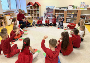 Dzieci z grupy 6 latków siedzą w kole na dywanie.