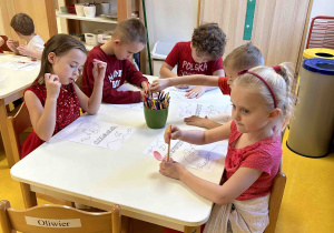 Dzieci kolorują przy stoliczkach.