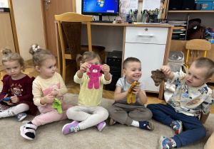 Przedszkolaki pokazują swoje misie.