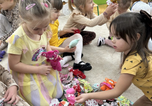 Dziewczynki wybierają spódniczki dla swoich misiów.