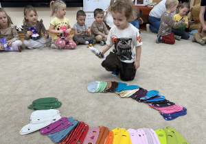 Chłopiec wybiera kamizelkę dla misia.