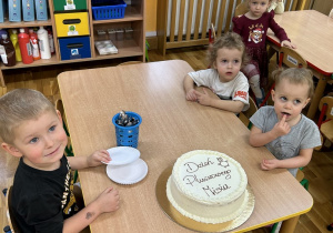 Trzylatki jedzą tort.