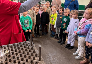 Dzieci słuchają pani przewodnik.