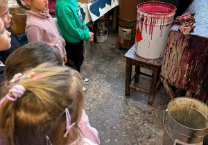 Dzieci oglądają proces malowania bombek.