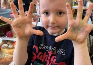 Chłopiec pokazuje rączki w brokacie.