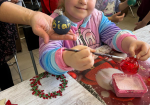 Dziewczynka ozdabia bombki.