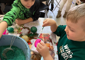 Chłopcy ozdabiają bombki.