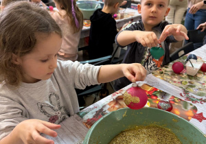Dzieci ozdabiają bombki.