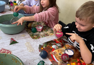 Dzieci ozdabiają bombki.