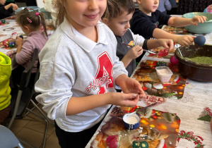 Dziewczynka ozdabia bombkę.