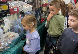 Dzieci zwiedzają sklepik z bombkami.