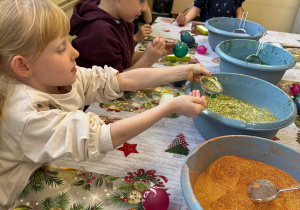 Dzieci ozdabiają bombki.