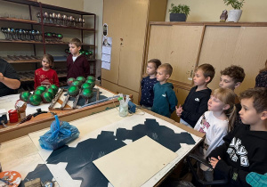 Dzieci obserwują jak panie ozdabiają bombki.