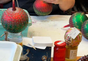 Pani dekoruje bombkę.