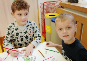 Chłopcy kolorują przy stoliczku.