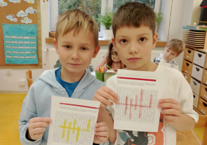 Chłopcy pokazują rozwiązaną wykreślankę.