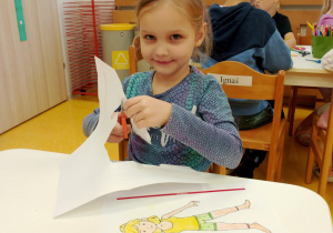 Dziewczynka wycina nożyczkami.