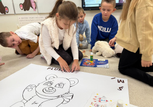 Dziewczynka układa napis z liter.