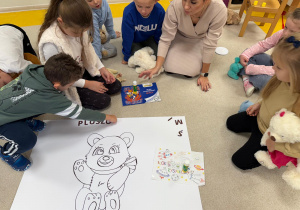 Chłopiec przykleja napis.