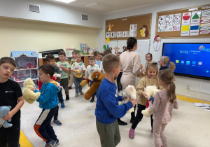 Dzieci tańczą w parze z misiami.