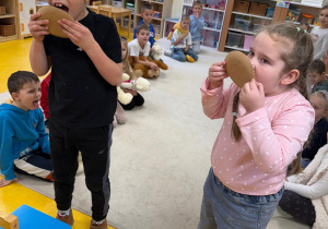 Dzieci zlizują miodek z talerzyka.