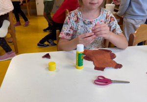 Dziewczynka wykonuje pracę plastyczną.