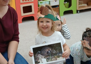 11. Dziewczynka trzyma ilustrację jeża.