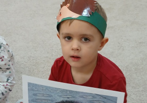 13. Chłopiec trzyma ilustrację jeża.