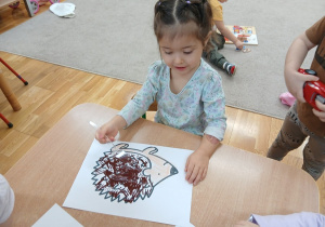 17. Dziewczynka odbiją widelcem kolce jeża.