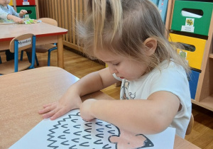 20. Dziewczynka wykonuje pracę plastyczną jeż.